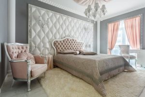 Pink, white, and cream-colored chic, and vintage bedroom with a white chandelier in a luxury residential home in Springfield, IL