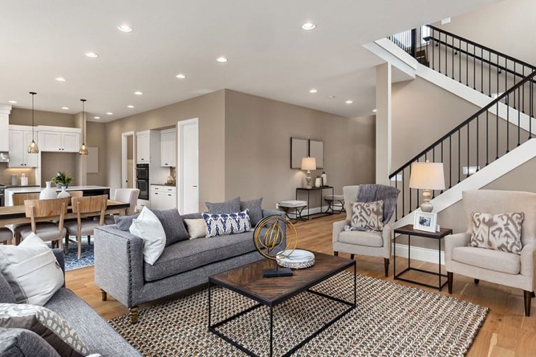 Modern open concept living room decorated with grey, tan, and white furniture and décor in a residential home in Petersburg, IL.