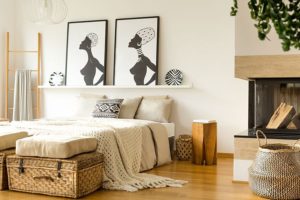 Modern organic bedroom space with light wood floors, a fireplace, light-colored décor, and wicker accessories that give off an organic look in Petersburg, IL.