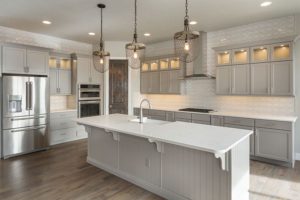 Farmhouse-style kitchen for a residential home in Petersburg, IL with all white cabinetry, stainless steel appliances, and wooden floors.
