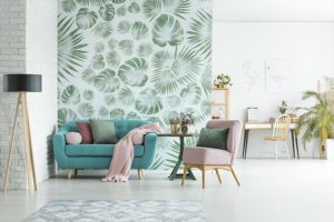 Green upholstered couch and pink sofa in a modern floral living room with green floral wallpaper and simple décor designs in Petersburg, IL.