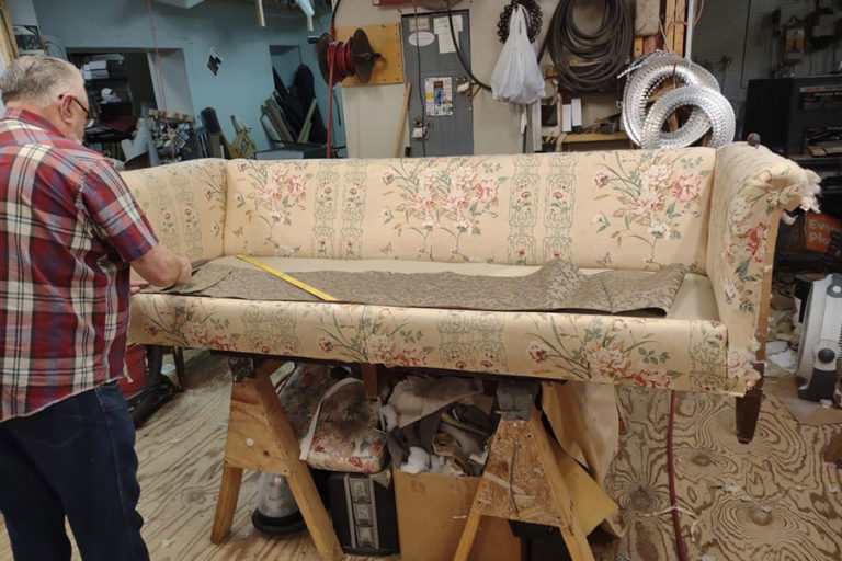 One of our experts in the process of reupholstering a couch for a client in Springfield, IL. Get custom fabric and patterns from our furniture shop.